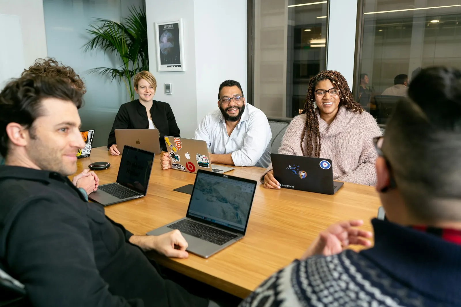Team meeting around a table with laptops